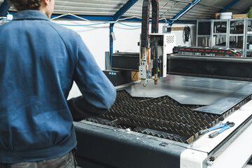 Steel worker on CNC plasma cutter machine, industry and technology. High quality photo