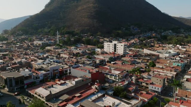 Aerial 360 orbit overlooking a residential area, the city center and the church of Tamazula de Gordiano