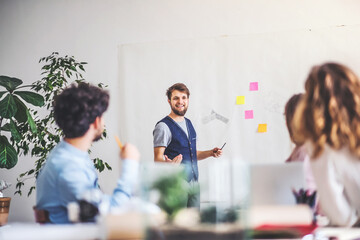 Young group of colleagues working on a new project together in a startup company office. Working in co-working space.