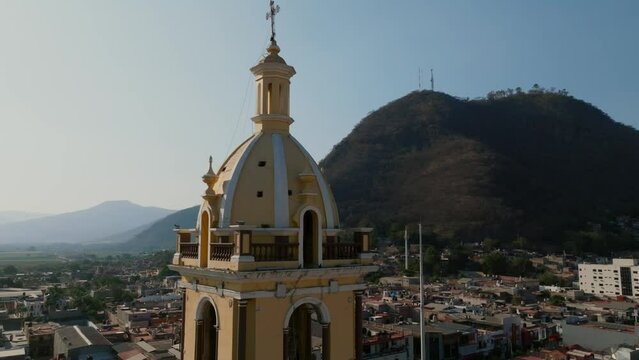 Aerial orbit of Santuario Diosesano bell tower and Cerro de la Mesa in Tamazula de Gordiano