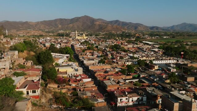 Fast aerial flight over neighborhoods in Tamazula de Gordiano, Mexico. Dolly in perspective