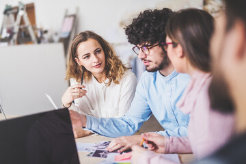Young group of colleagues working on a new project together in a startup company office. Working in co-working space.