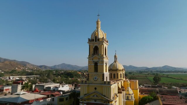 Establishing aerial of the Santuario Diosesano catholic church facade in Tamazula de Gordiano, dolly in tilt up