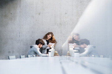 Young university students studying togeter in library, talking, preparing for final exam. Study...