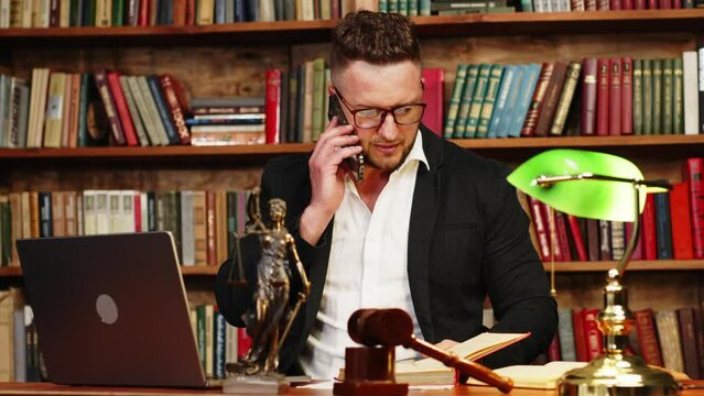 A lawyer or lawyer in his office conducts a consultation by telephone. Justice and law concept, modern technology.