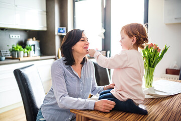 Grandma takes care of the grandchildren while parents are at work, helping with the little girl.