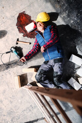 An unconscious man worker lying on the floor after a head injury. Work injury, accident in...