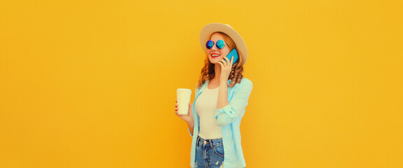 Happy cheerful smiling young woman calling on mobile phone wearing summer hat on yellow background
