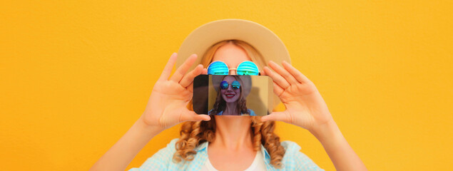 close up of modern happy young woman taking selfie with smartphone on yellow background