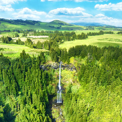 Aerial view of a remote waterfall Grená in Furnas surrounded by a dense forest in the Azores, Portugal
