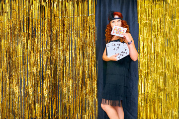Cute woman with playing cards the host of the event, party, wedding on golden