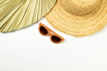 Top view of straw hat, dried palm leaf and sunglass on white background. Summer fashion, vacation...