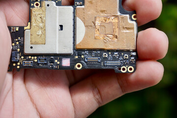 Cellphone printed circuit board (PCB) (mainboard mother board) that powers most of our phone nowdays. Black color with many surface-mounted components and Zero Insertion Force (ZIF) connectors.