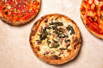 Top view of three different Italian pizza. White Pizza with cheese, sausages and Rapini or broccoli...