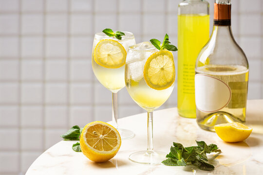 The Limoncello Spritz cocktail, delightful combination of limoncello, sparkling wine and soda with lemon, ice and mint. Italian summer drink. White background.