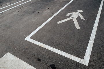 Pedestrian path sign on asphalt ground, symbol of a man walking