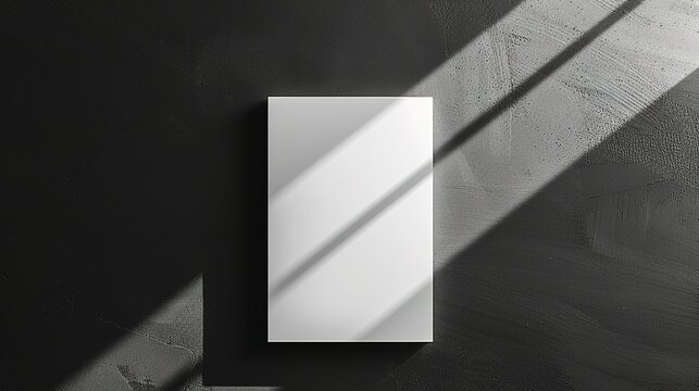 Minimalist mockup of a blank canvas on a dark wall with dramatic sunlight casting shadows, perfect for showcasing artwork or design projects.