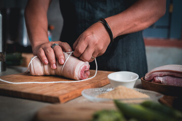 Men tie ropes and cut pork to make Japanese-style pork slices.