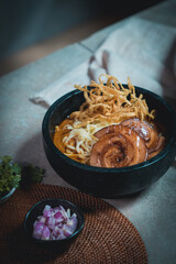 Khao Soi, a local dish of northern Thailand, is filled with various spices including lime, shallots, and chili.