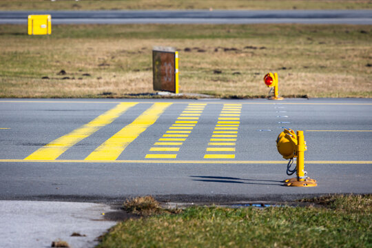 Runway holding point with stop bars and red lights. Airport safety infrastructure.