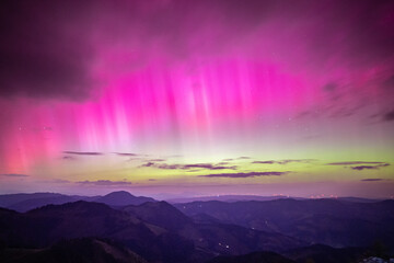 Colorful green and pink northern lights over the alps of central europe, Austria. Aurora borealis...