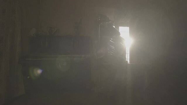 Abandoned piano, lamp, curtains and furniture in a derelict old palace with dust particles in the air at sun light (S-Log 3, Camera travelling, ProRes 422HQ, 4K)