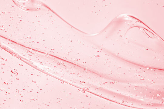 Serum liquid gel texture. Pink beauty skincare background. Cosmetic cream with bubbles closeup