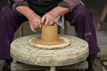 hands of a potter working the ceramic clay, traditional works concept