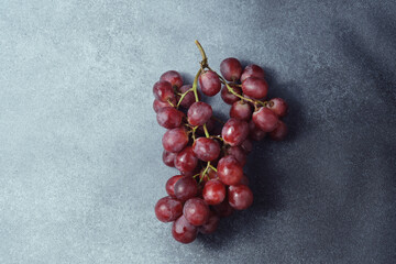 Luscious Red Grapes Bunch on a Coarse Textured Grey Surface