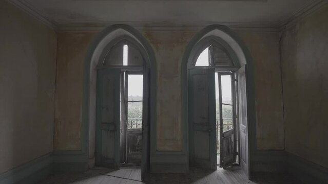 Abandoned empty room of an old palace with gothic style arch broken windows (S-Log 3, 4K, ProRes 422HQ)