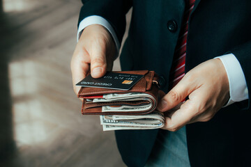 Businessman holding credit card with wallet with dollar bills. Credit card concept. Online payment....