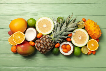 Set of tropical fruit on green wooden background, top view