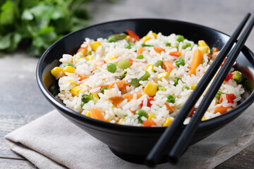 White fried rice with vegetables on wooden table