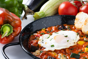 Vegetable pisto manchego with tomatoes, zucchini, peppers, onions,eggplant and egg, served in...
