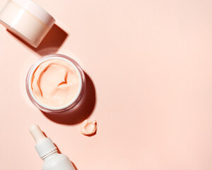 Skin care border - open jar and swatch of pink beauty cream