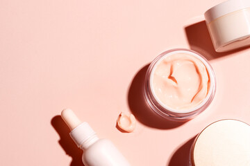 Skin care border - open jar and swatch of pink beauty cream