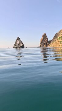 Sea water surface. Low angle view from kayak, camera flies over clear calm sea water. Nobody. Holiday recreation concept. Abstract nautical summer ocean nature. Slow motion. Close up. Vertical video