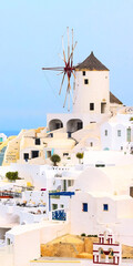 Santorini island, Greece, Oia village windmill close-up and white houses, vertical banner