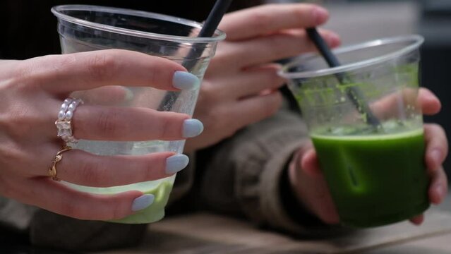Girls chugging drinks at a coffee shop. Matcha latte in hand. Friends in a coffee shop. A group of friends in a coffee shop.