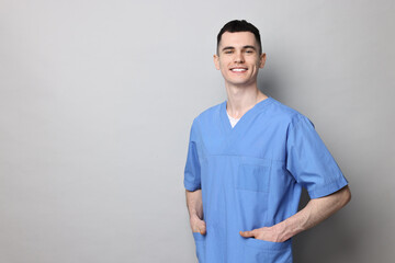 Portrait of smiling medical assistant on grey background. Space for text