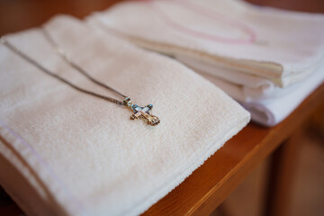 Obraz premium Set for baptism. a white dress and towels with a cross on the body. Christian faith and traditions.