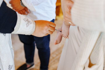 Obraz premium The priest conducts the process of anointing with oil for baptism. Christian faith and traditions.