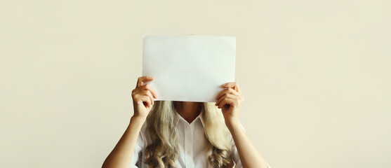 Woman showing and holding white blank sheet of paper document for advertising text blank copy space