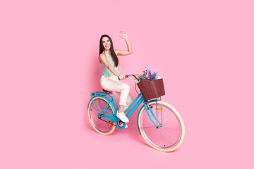 Photo of cute cheerful lovely woman wear stylish clothes walk bicycle meeting isolated on pink...