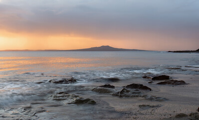 Sunrise over Rangitoto Island. Milford Beach. Auckland.