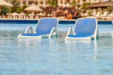 Picture of two sun beds in the water pool