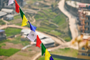 Colorful Tibetan prayer flags on blurred Kathmandu cityscape background symbolizing cultural value...