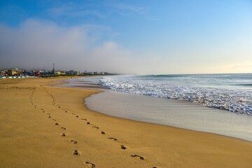 Footprints on the sand of an empty beach near a city, the southern point of Africa