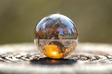 a glass globe with its reflection sitting on top of a table