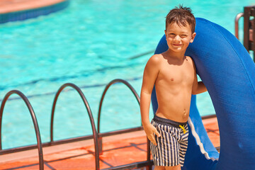 Picture of a small boy having fun in aquapark outdoor on tube